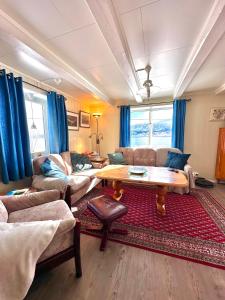 Cozy home in Godfjord في سورتلاند: غرفة معيشة مع أريكة وطاولة