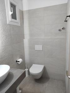 a bathroom with a white toilet and a sink at Vythos in Adamas