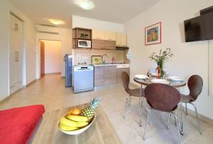 uma cozinha com uma mesa e uma taça de fruta no chão em Nette Wohnung in Šilo mit Möblierter Terrasse em Šilo
