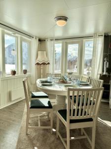 uma sala de jantar com uma mesa branca e cadeiras em Cozy home in Godfjord em Sortland
