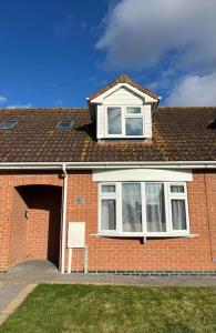 a brick house with a window and a roof at Annie's Hideaway in Chapel Saint Leonards