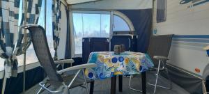 een tafel en stoelen in een kamer met een tafel en een spiegel bij Caravan Finca La Vida Rustica in Maella