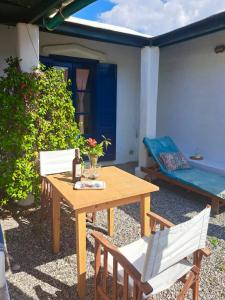 uma mesa de madeira com duas cadeiras e uma cama em Arancio independent room in Ecovilla on the beach em Apolakkiá