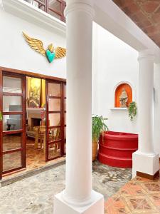 a white pillar in a room with a red table at Casa Balam Bed & Breakfast Boutique in Ciudad Vieja