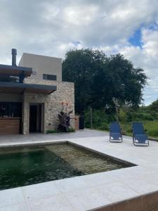 two chairs and a pool in front of a house at Loto San Lorenzo I Studio in San Lorenzo