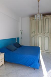 - une chambre avec un lit bleu et un lustre dans l'établissement Appartamentino Nadia, à Monterosso al Mare