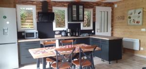 eine Küche mit einem Tisch und einigen Stühlen in der Unterkunft Le Clos du Jardinier in Châtillon-sur-Seine