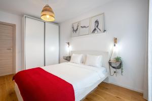 a bedroom with a large white bed with a red blanket at Papini's Apartment -apartment with big terrace in Bucharest