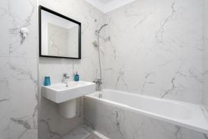a white bathroom with a sink and a bath tub at Papini's Apartment -apartment with big terrace in Bucharest +23 photos