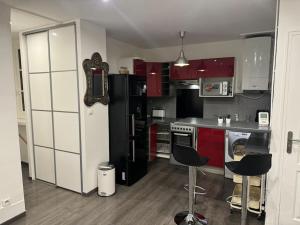 una cocina con armarios rojos y blancos y electrodomésticos negros en Cosi apartment near La Défense, en Courbevoie 34 fotos más