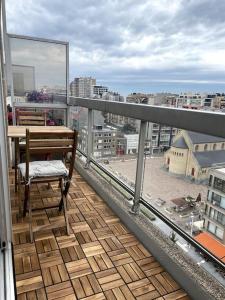 a balcony with a table and a view of a city at Fully renovated studio with nice view! in Nieuwpoort
