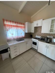 a kitchen with white cabinets and a sink at Thrillers for the guest that works remote in True Blue