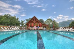 賽維爾維爾的住宿－Bears Valley Inn - Less than 15 Min to Attractions - Great Mtn Views - Private Pool Club - EZ Access Roads - Luv Dogs!，一座带椅子的大型游泳池和一座建筑