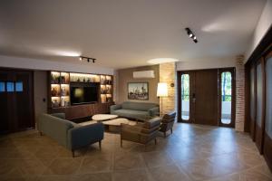 a living room with a couch and chairs and a tv at Camp David Ranch in Santiago de los Caballeros