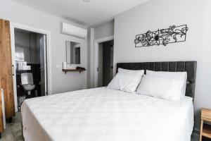 1 dormitorio con cama blanca y cabecero negro en The Han YK Hotel, en Avcılar
