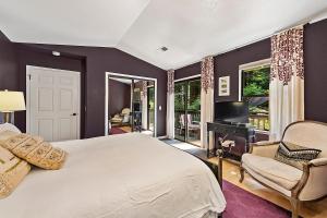 a bedroom with a large white bed and a television at Camp Ciyole in Guerneville