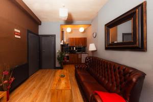 a living room with a leather couch and a mirror at Warm, Cozy&Relaxed Apartment by Holyrood Palace in Edinburgh