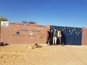 a group of people standing in front of a fence at Camping-Auberge Odette du Puigaudeau et Aziza in Atar