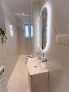 Apartman No. 3 في زغرب: حمام أبيض مع حوض ومرآة