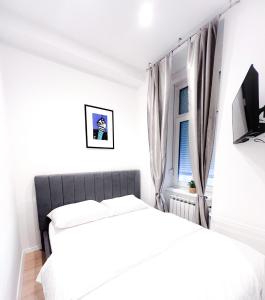 Apartman No. 3 في زغرب: غرفة نوم بيضاء بها سرير ونافذة