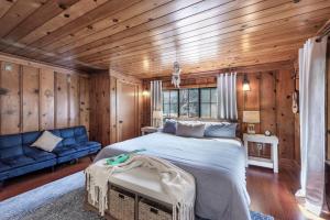 1 dormitorio con 1 cama grande y 1 sofá azul en Rivendell, en Monte Rio