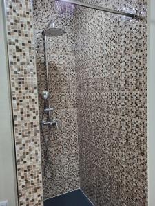 ein Bad mit einer Dusche mit braunen Fliesen in der Unterkunft Trilhos do Diabo, T1 in Vila do Conde