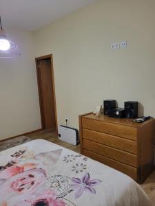 - une chambre avec un lit et une commode en bois dans l'établissement Trilhos do Diabo, T1, à Vila do Conde