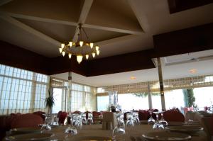 a dining room with tables and chairs and a chandelier at Atamer Doga Resort in Gemlik