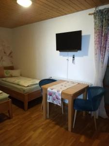 a room with a table and a bed and a tv at Meyerhof in Wittenweier