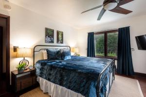 Un dormitorio con una cama y un ventilador de techo. en Rocktop Lodge, en Forestville