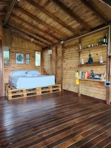 Cabaña en Medio del Bosque con Jacuzzi - Santa Elena في سانتا إيلينا: غرفة نوم بسرير في كابينة خشبية