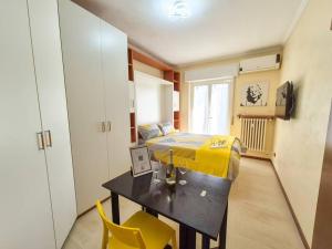 a bedroom with a bed and a table and yellow chairs at Milano/Cinisello Tram 31 (M5 BIGNAMI) in Cinisello Balsamo