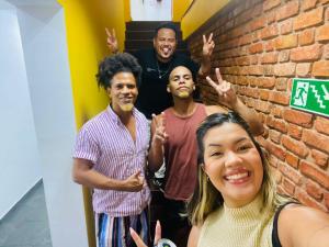 un grupo de personas de pie junto a una pared de ladrillo en Arcos Da Lapa Hostel, en Río de Janeiro