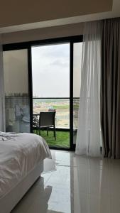 una camera con un letto e una grande finestra in vetro di شقة فندقية ALzorah Ajman - الزوراء عجمان ad Ajman