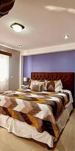 a bedroom with a large bed with a purple wall at ‘La Casa Roja’ in Quetzaltenango