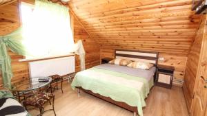 1 dormitorio con 1 cama en una cabaña de madera en Розмарин, en Mykulychyn