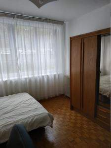 um quarto com uma cama, uma cómoda e uma janela em Spacious Condo, Green Serenity em Palaiseau