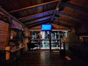 Cabaña en Medio del Bosque con Jacuzzi - Santa Elena في سانتا إيلينا: غرفة معيشة مع تلفزيون ونافذة كبيرة