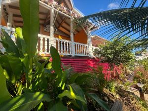 una casa con portico e alcune piante di L'escale Tropicale a Sainte-Anne