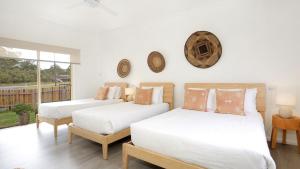 a bedroom with two beds and a window at Bungalow 21 in Callala Beach