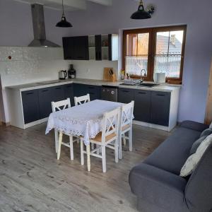 a kitchen with a table and chairs and a couch at Słoneczne zbocze in Wysowa-Zdrój