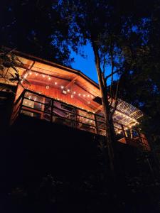 una casa con luces al costado de ella por la noche en Cabaña en Medio del Bosque con Jacuzzi - Santa Elena, en Santa Elena