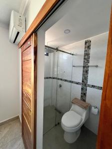 uma casa de banho com um WC e uma cabina de duche em vidro. em Residencia Vigonza em Puerto López
