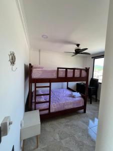 2 beliches num quarto com uma ventoinha de tecto em Residencia Vigonza em Puerto López