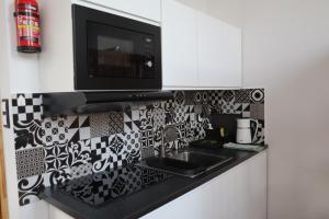 a kitchen with a sink and a microwave at Apartamenty Słoneczny Wieczór in Braniewo