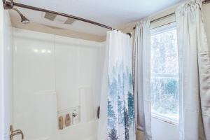 - un rideau de douche dans la salle de bains pourvue d'une fenêtre dans l'établissement Serene Guion Cabin Less Than 1 Mi to the White River!, 