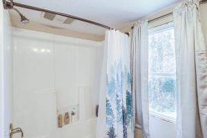 a shower curtain in a bathroom with a window at Serene Guion Cabin Less Than 1 Mi to the White River! in Guion