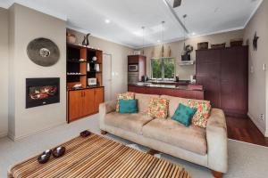 a living room with a couch and a fireplace at Sanctuary Palms in Paihia