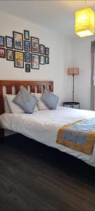 1 cama en un dormitorio con cuadros en la pared en Spacious London apartment 5 min walk to Leytonstone Underground Station and 5 stops to zone 1 en Londres