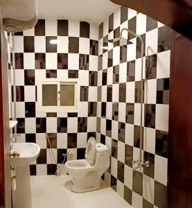 baño con pared a cuadros en blanco y negro en فندق وسط البلد en Riad